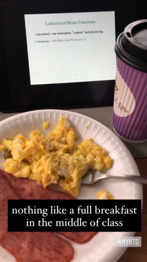 A plate of breakfast and cup of coffee in front of a screen displaying a course slide titled, Lateralized Brain Functions.