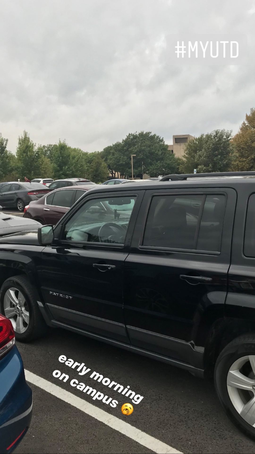  Yawn emoji. A black Jeep Patriot in a campus parking lot.