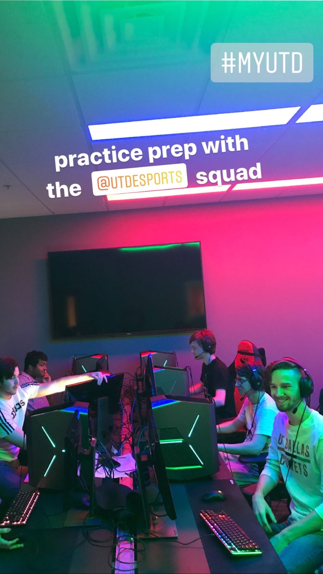  Pictured, five members of esports team seated at computers.