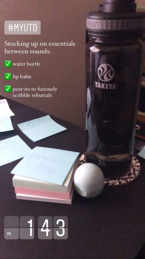 On a table top, a stock of post-it notes, a round lip balm container, and a water bottle labeled, Takeya.