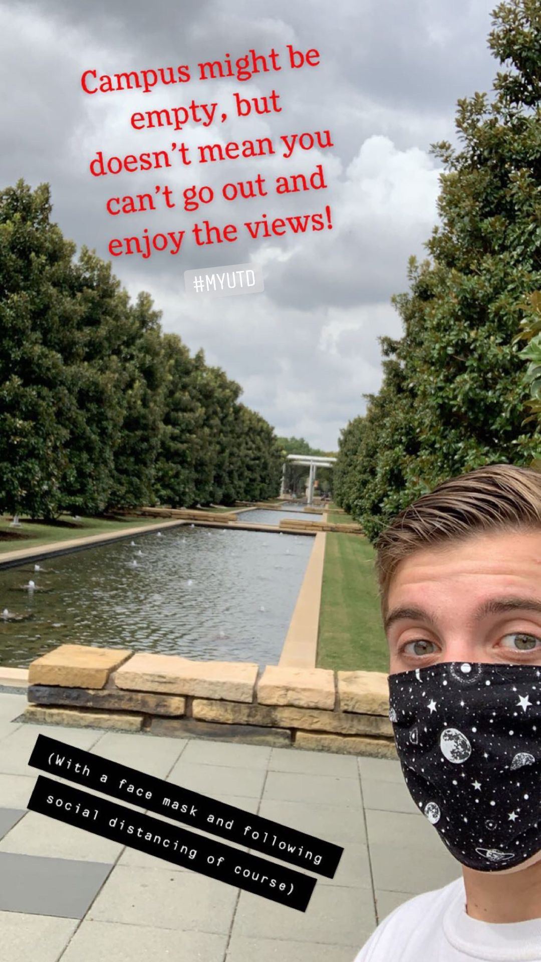 Selfie of Trent, wearing a mask, with campus's tree-lined reflecting pools in the background. 