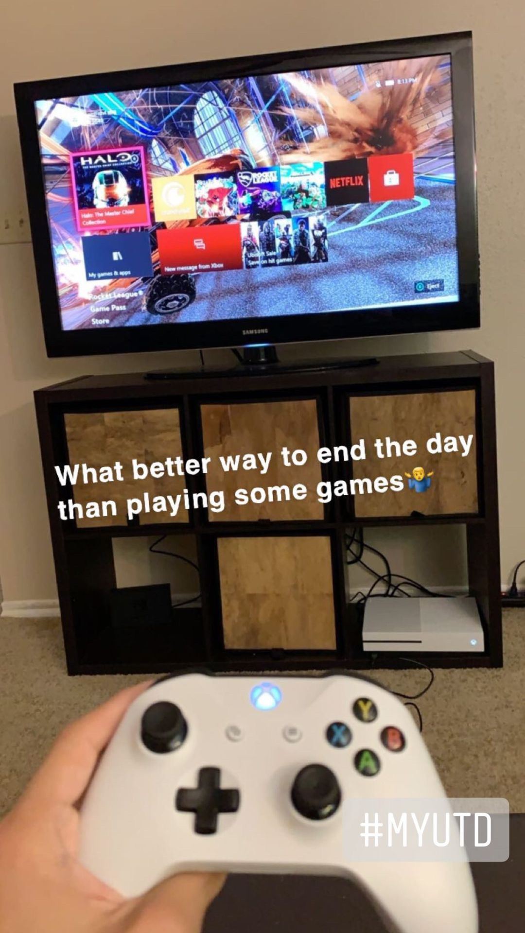 Trent's hand holding an xbox controller. A TV on a stand is in front of him. Shrug emoji. 