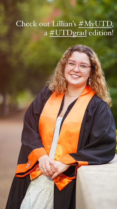 Lillian poses outdoors in graduation robe with orange sash.