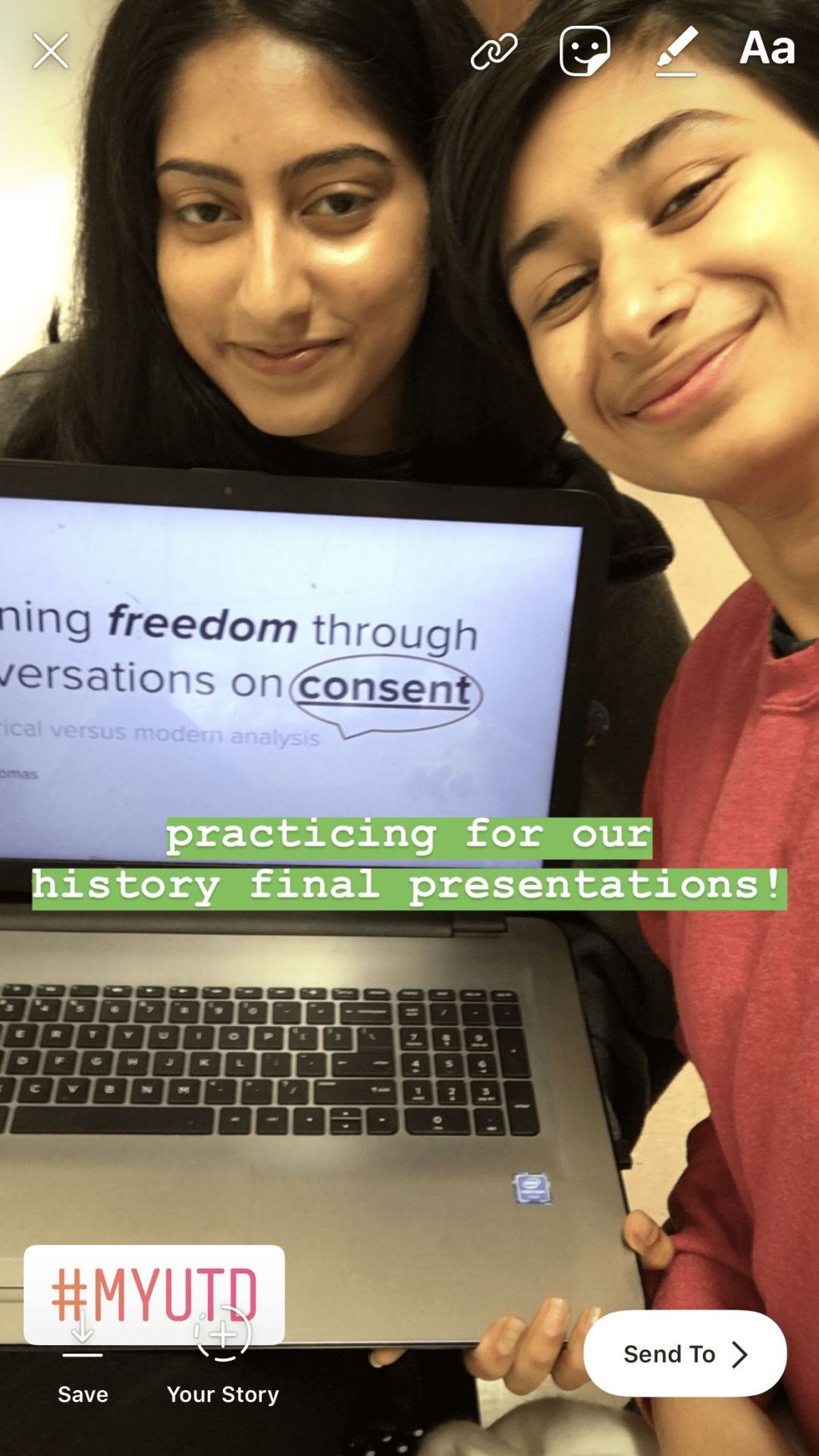 Ragya and another person take a selfie together. They're holding a laptop; part of the screen is visible with the words, freedom through conversations on consent.