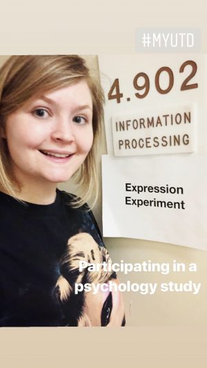 Rowan, smiling, stands beside a sign that reads, 4.902, Information Processing, Expression Experiment.