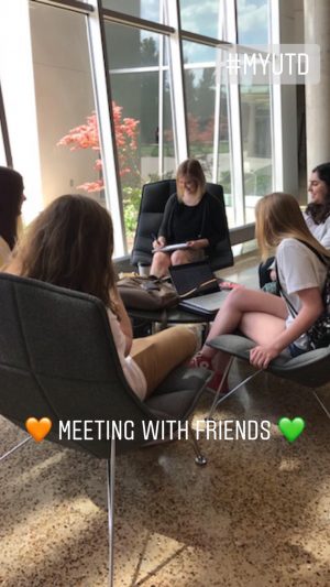 Orange and green hearts surround the text, meeting with friends. Pictured, Rowan and four others are seated around a low table in the ATEC building.