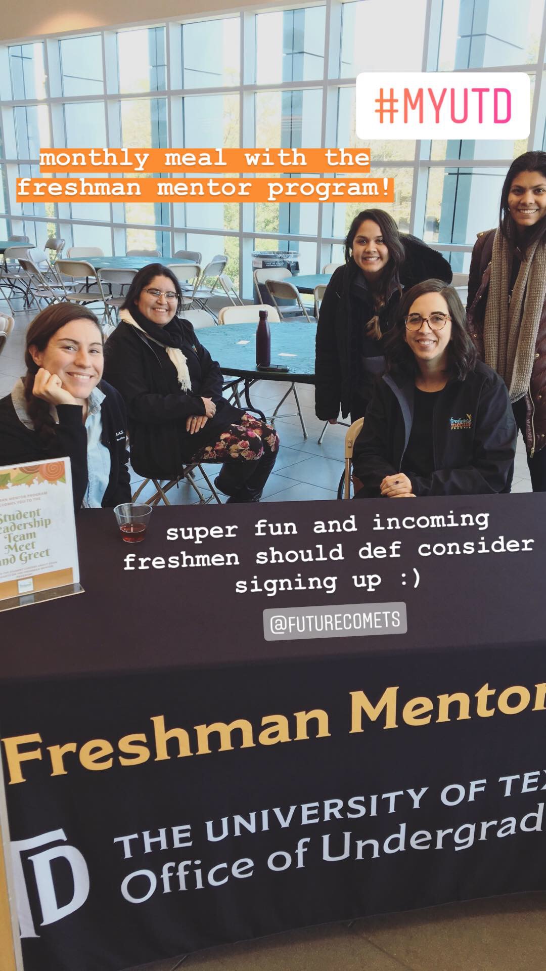 Five students gathered around a table with a tablecloth that reads, Freshman Mentor.
